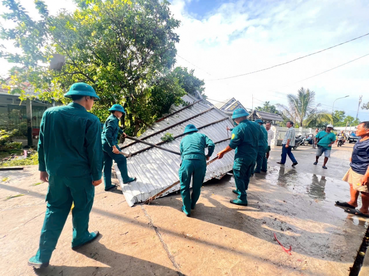 Cán bộ, chiến sĩ LLVT phường Vĩnh Thông giúp dân khắc phục hậu quả lốc xoáy.