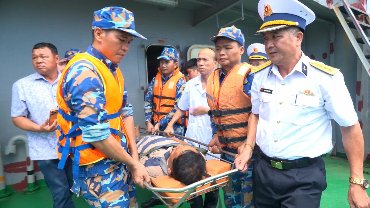 Đại tá Nguyễn Xuân Dũng cùng cán bộ, chiến sĩ và lực lượng quân y đưa ngư dân Nguyễn Đức Quốc từ tàu  lên bờ
