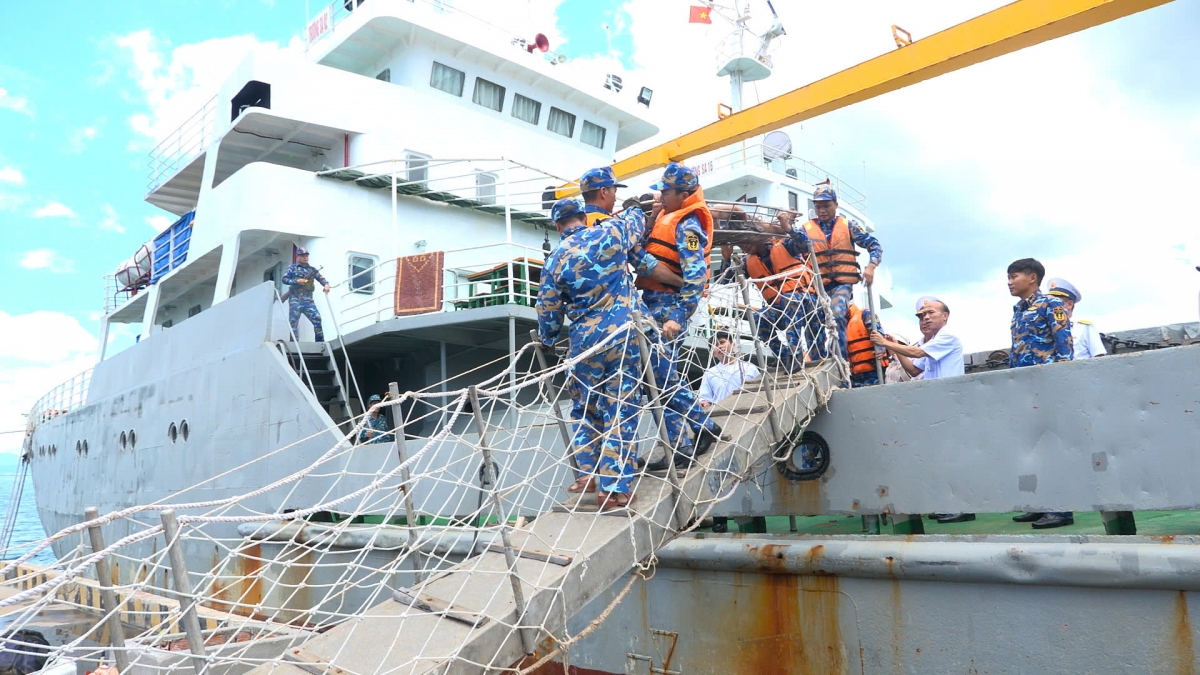 Cán bộ, chiến sĩ và lực lượng quân y đưa ngư dân Nguyễn Đức Quốc từ Tàu TS16 lên bờ