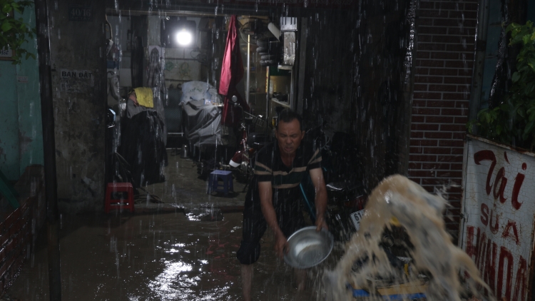 Hễ mưa lớn, người dân ven Quốc lộ 13 phải tát nước khỏi nhà