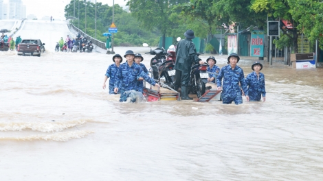 Cảnh sát biển hỗ trợ người dân di chuyển qua vùng ngập sâu khu vực cầu Ngà