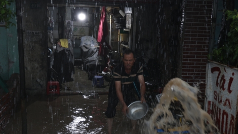 Hễ mưa lớn, người dân ven Quốc lộ 13 phải tát nước khỏi nhà
