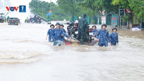 Cảnh sát biển hỗ trợ người dân di chuyển qua vùng ngập sâu khu vực cầu Ngà