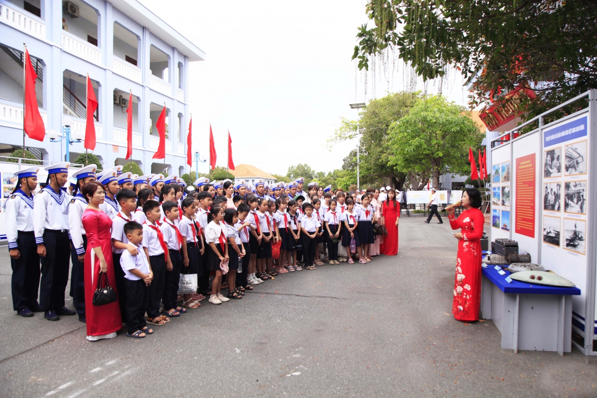 Các em học sinh và chiến sĩ hải quân cùng nghe thuyết trình về các tư liệu, hình ảnh, bản đồ... về quần đảo Hoàng Sa và Trường Sa