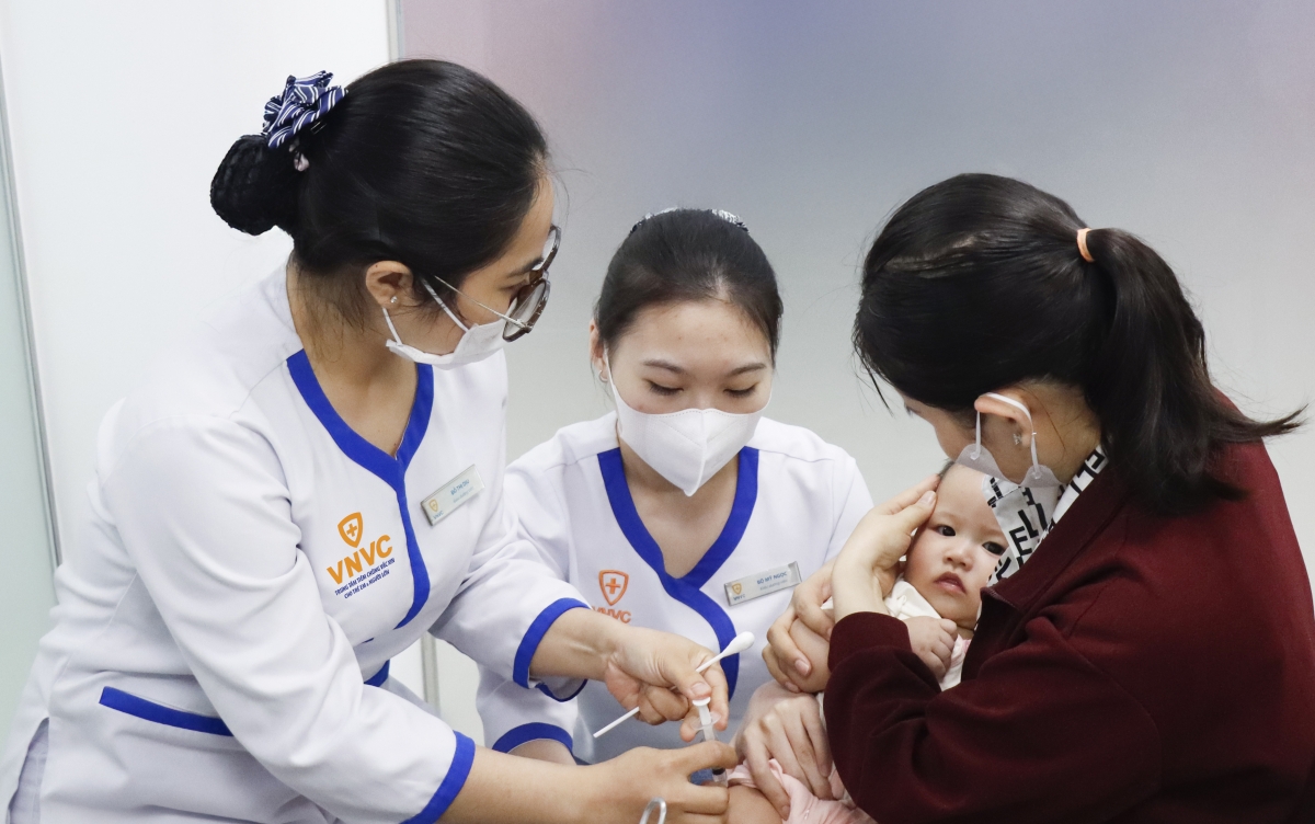 Các nhân viên y tế Trung tâm tiêm chủng VNVC tiêm vắc xin phòng bệnh cho bé