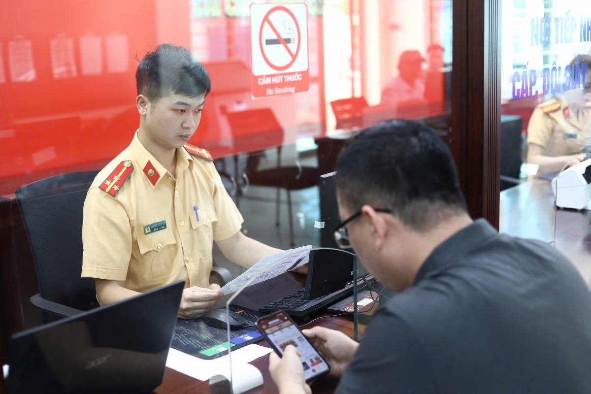 Chiến sỹ CA hướng dẫn người dân khai thủ thục cấp đổi GPLX quaVNeID