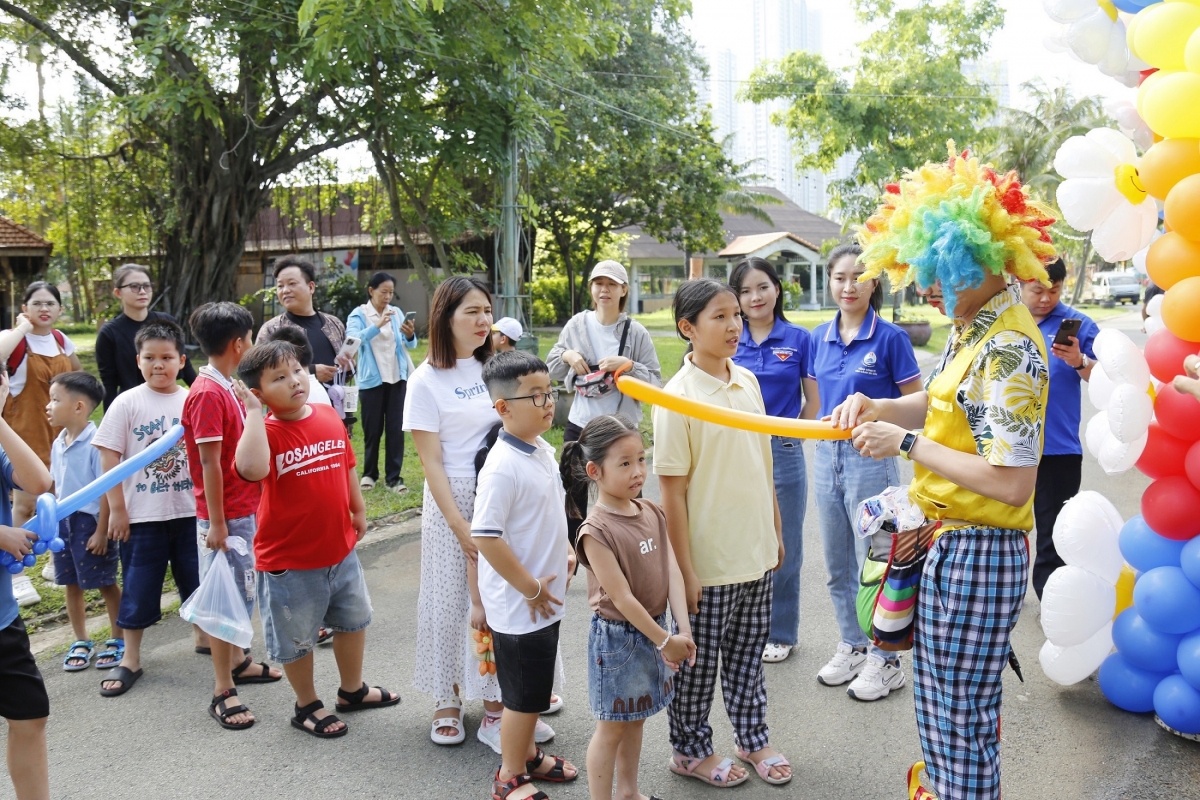 Các em thiếu nhi xếp hàng nhận những đồ chơi bóng bay
