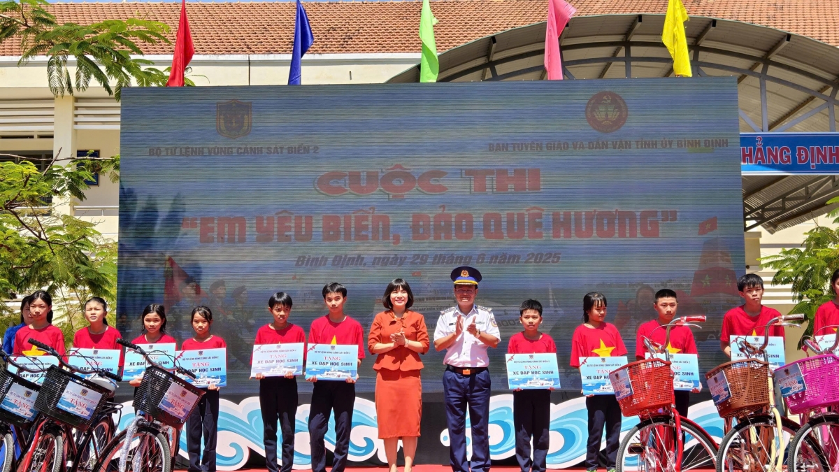 Đồng chí Đại tá Lê Huy, Chính ủy Vùng Cảnh sát biển 2 và đồng chí Nguyễn Thị Bích Ly, phó Trưởng ban Tuyên giáo và Dân vận tỉnh ủy Bình Định trao học bổng tặng học sinh.