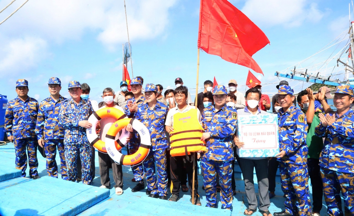 Phó Đô đốc Trần Thanh Nghiêm, Tư lệnh Hải quân (thứ 4 từ phải qua) tặng áo phao, cờ Tổ quốc cho ngư dân đánh bắt hải sản trên quần đảo Trường Sa