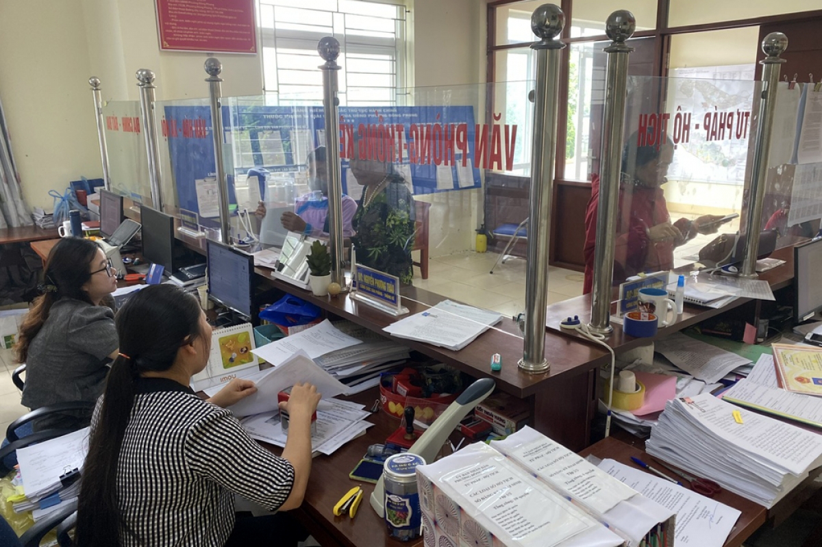 Cán bộ hướng dẫn người dân hoàn thiện thủ tục hành chính.
