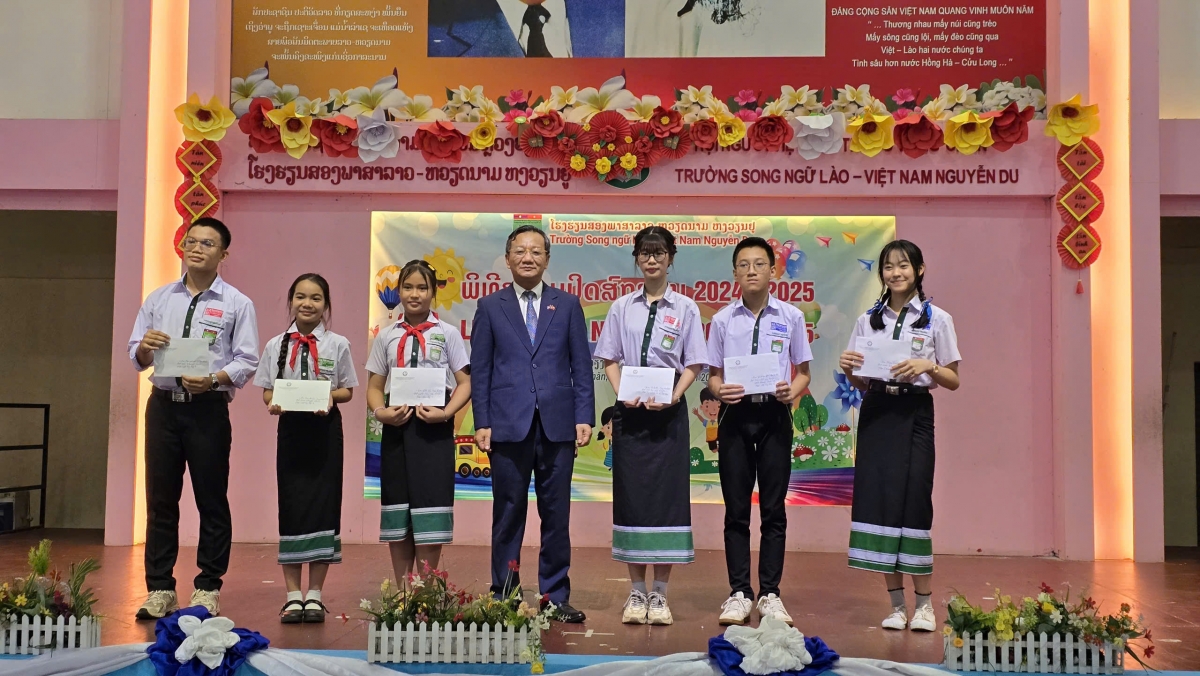 Đại sứ Việt Nam tại Lào Nguyễn Minh Tâm trao phần thưởng cho các em học sinh giỏi cấp huyện và thành phố.