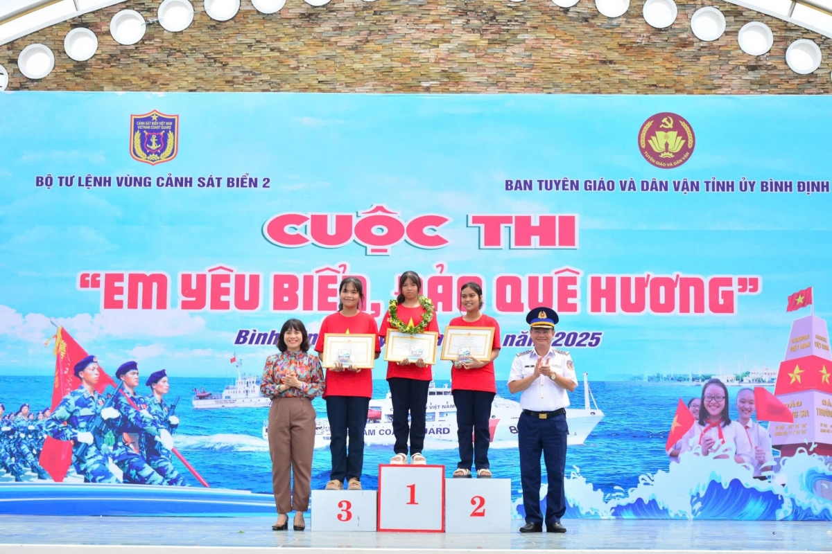 Đồng chí Đại tá Lê Huy, Chính ủy Vùng Cảnh sát biển 2 và đồng chí Nguyễn Thị Bích Ly trao giải tặng các thí sinh giải Nhất, Nhì, Ba trong cuộc thi “Em yêu biển, đảo quê hương” tại xã Nhơn Châu năm 2025.