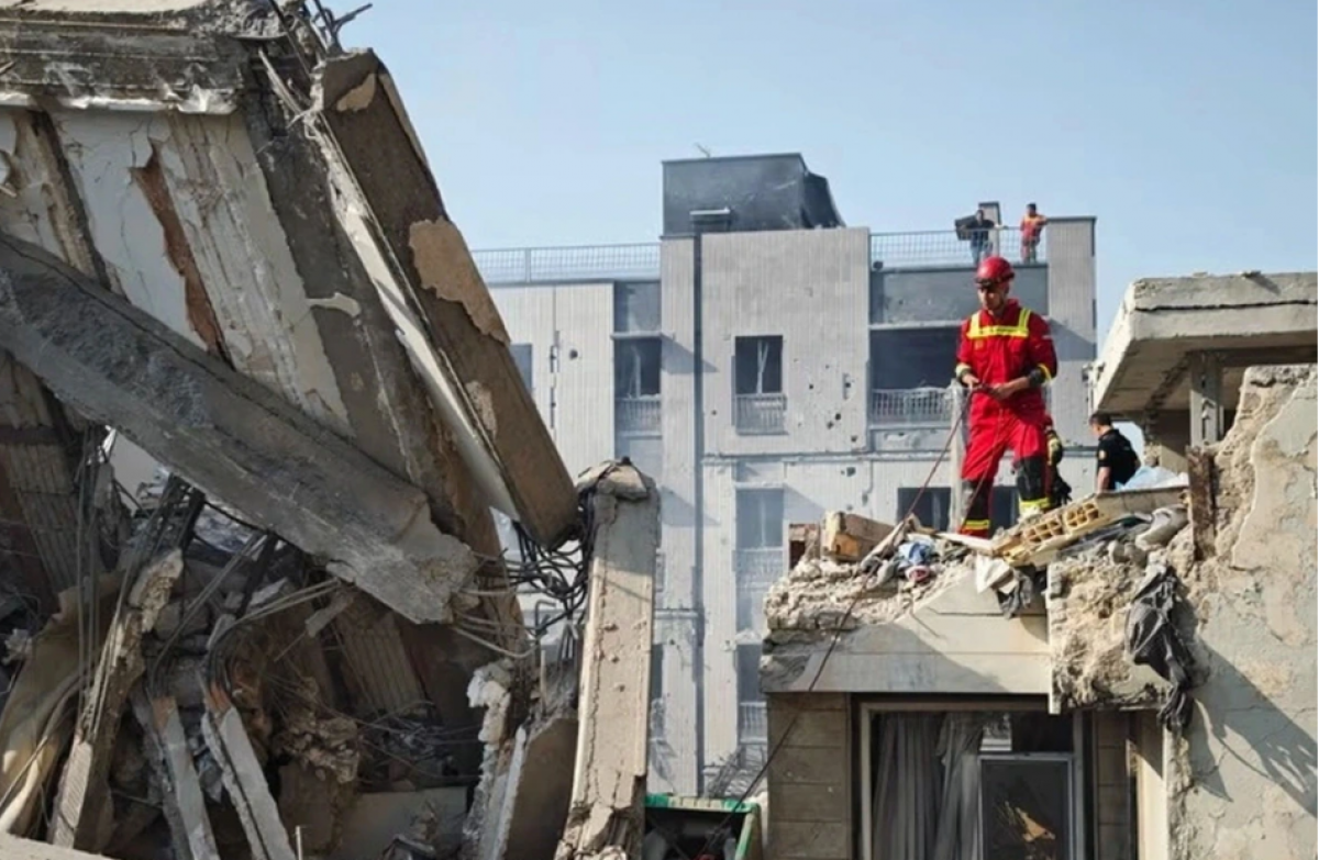 Lực lượng cứu hộ tại một tòa nhà ở Tehran (Iran) bị hư hại do trúng hỏa lực Israel. (Ảnh: Reuters)