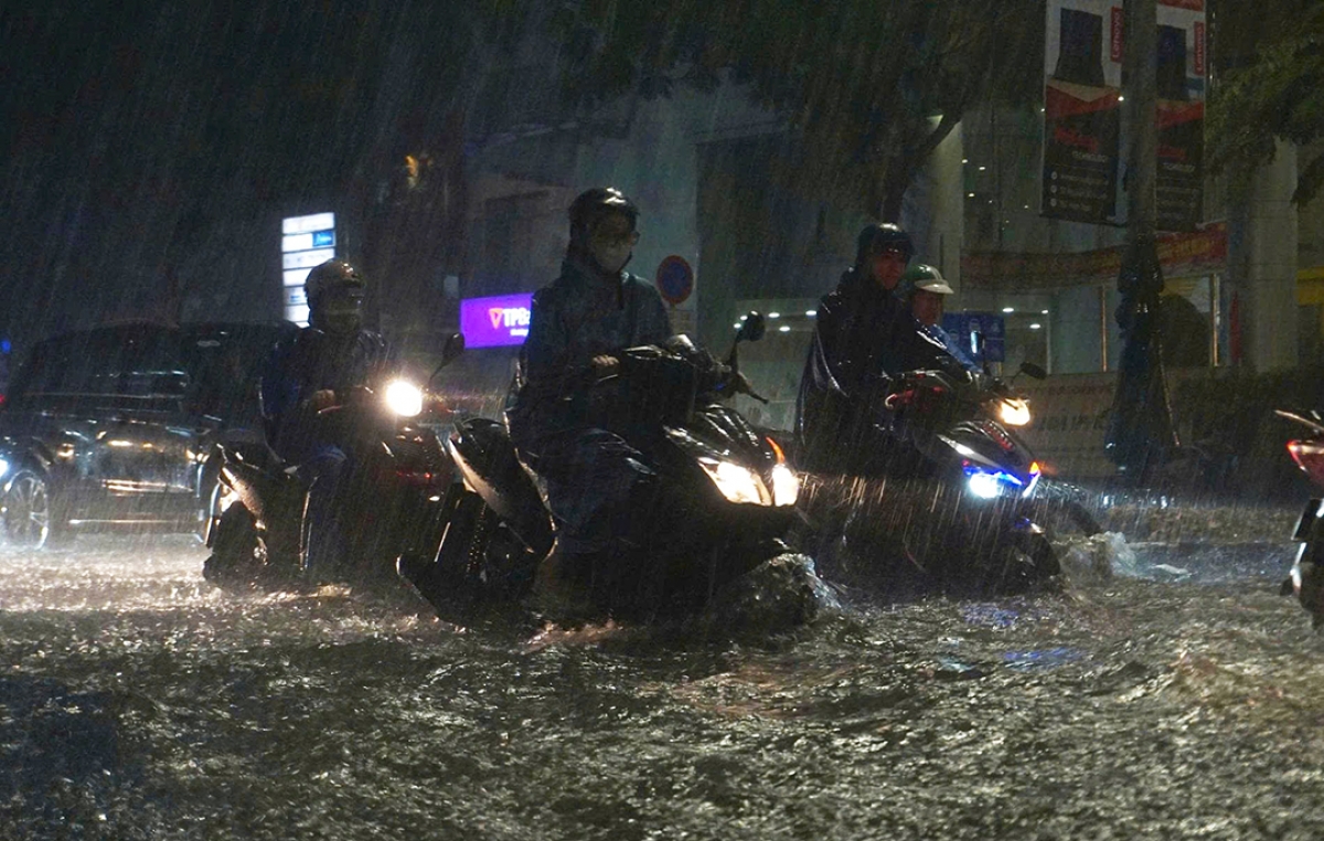 Người dân đi làm về gặp mưa to, nước ngập nên việc đi lại cẩn trọng hơn