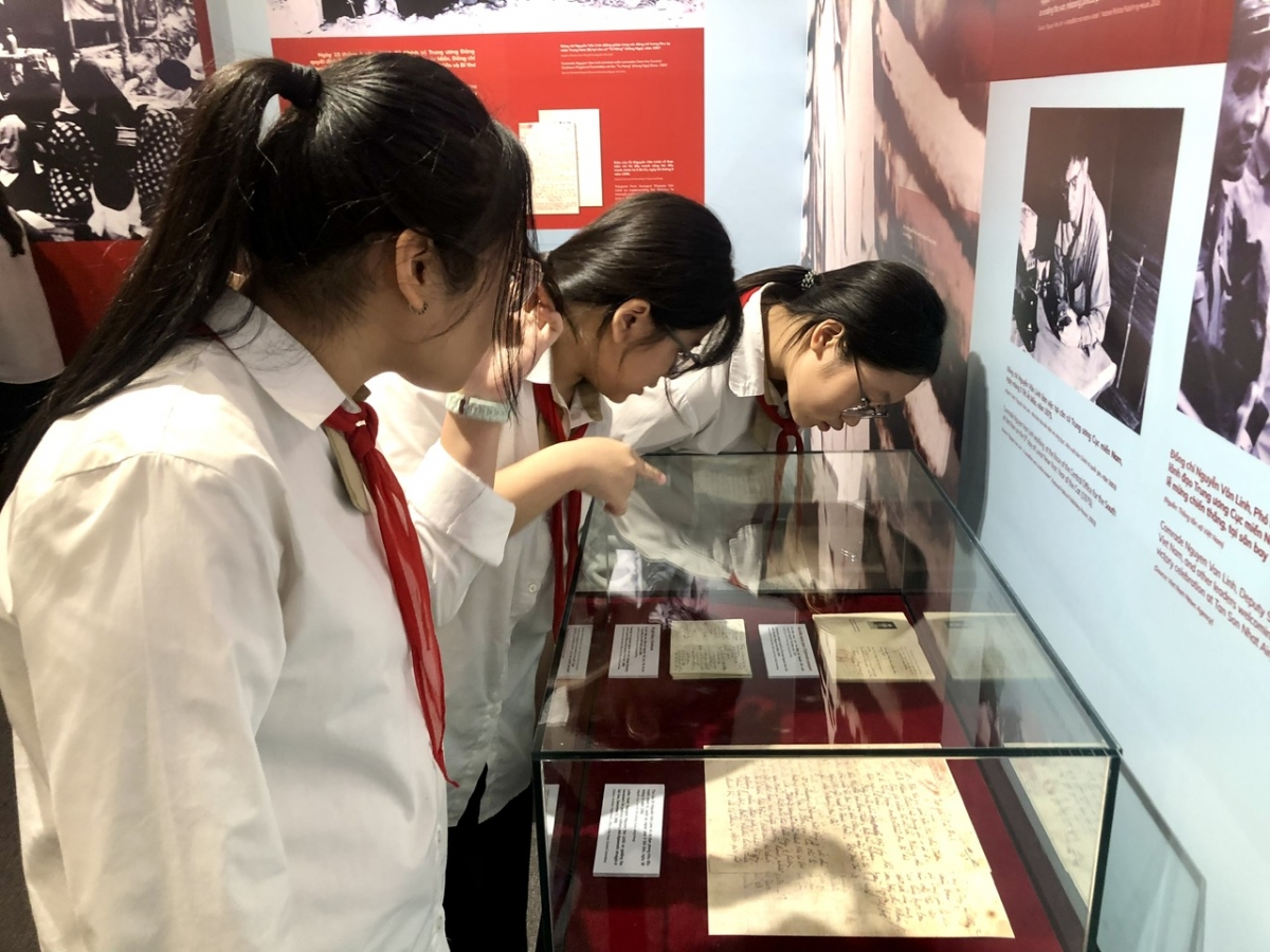 Các cháu học sinh say mê đọc tài liệu, hiện vật về TBT Nguyễn Văn Linh