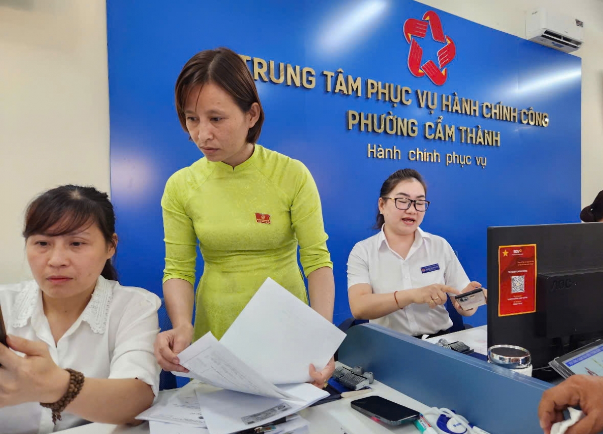 Chị Tạ Thị Thanh Thủy (mặc áo dài) đang hỗ trợ cán bộ tại trung tâm phục vụ hành chính công phường Cẩm Thành