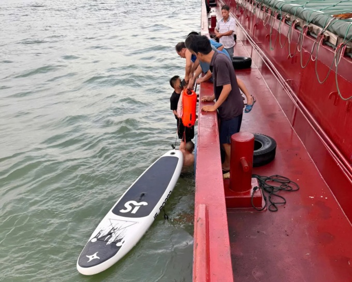 Lực lượng cứu hộ đưa bé gái từ thuyền kayak lên tàu, sáng 31/7