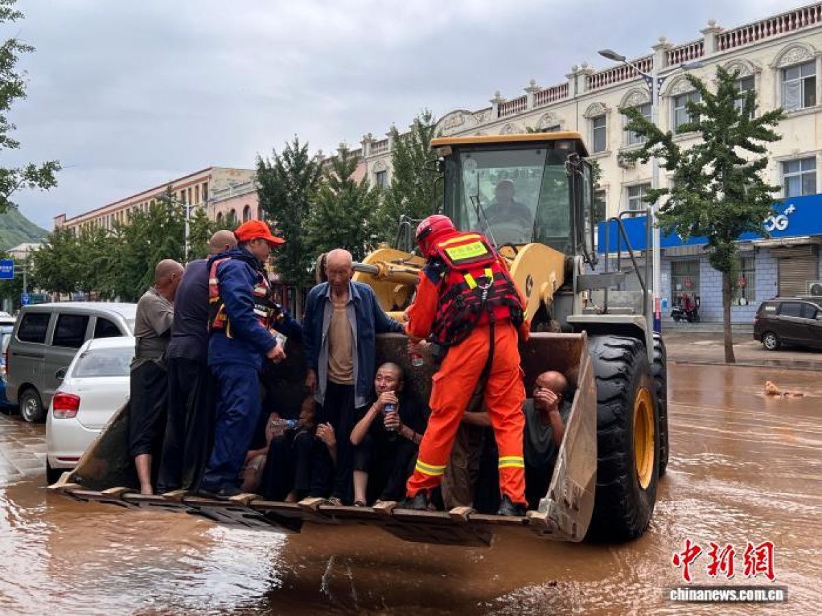Ngày 28/7, lực lượng cứu hộ đã hỗ trợ người dân sơ tán khỏi một ngôi làng ở quận Mật Vân, Bắc Kinh. Ảnh: Chinanews