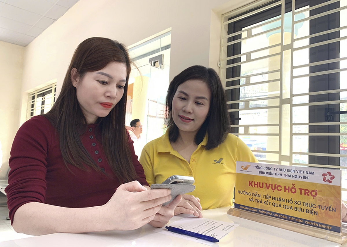 Nhân viên bưu điện hỗ trợ người dân làm thủ tục hành chính