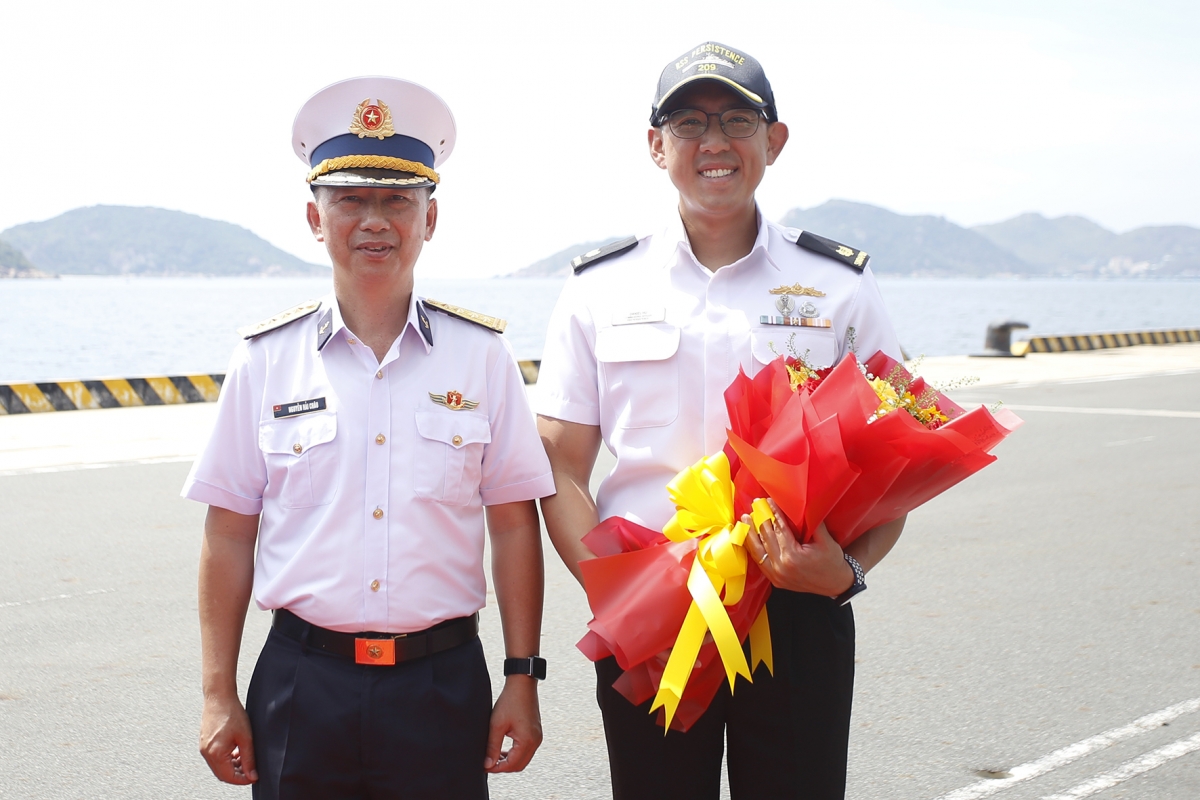Đại tá Nguyễn Hải Châu đón và tặng hoa Thiếu tá Hu Junjie Daniel
