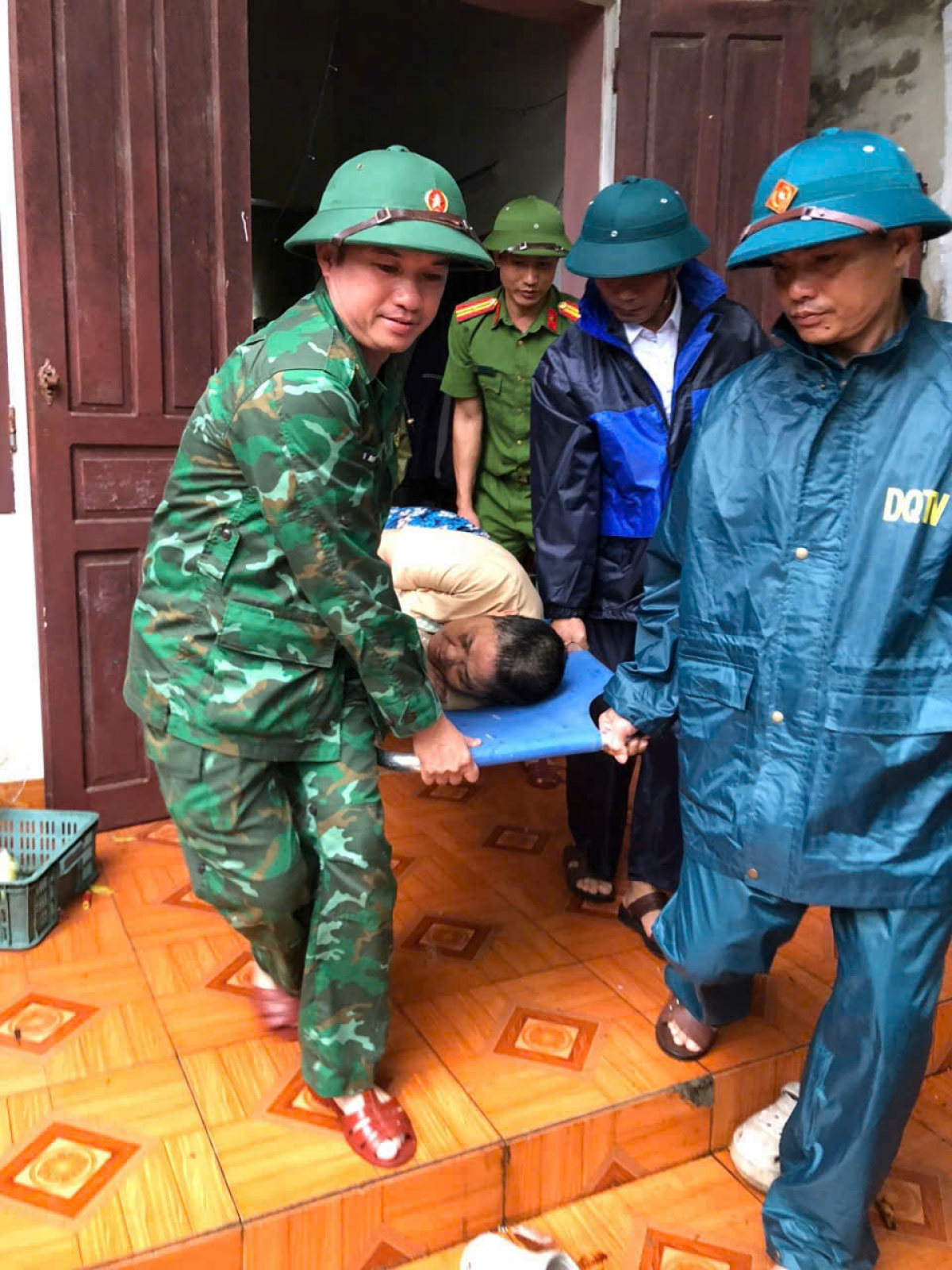 Cán bộ Đồn Biên phòng Hải Hòa và lực lượng chức năng giúp người dân di dời đến nơi an toàn (Ảnh: Hải Chuyền)