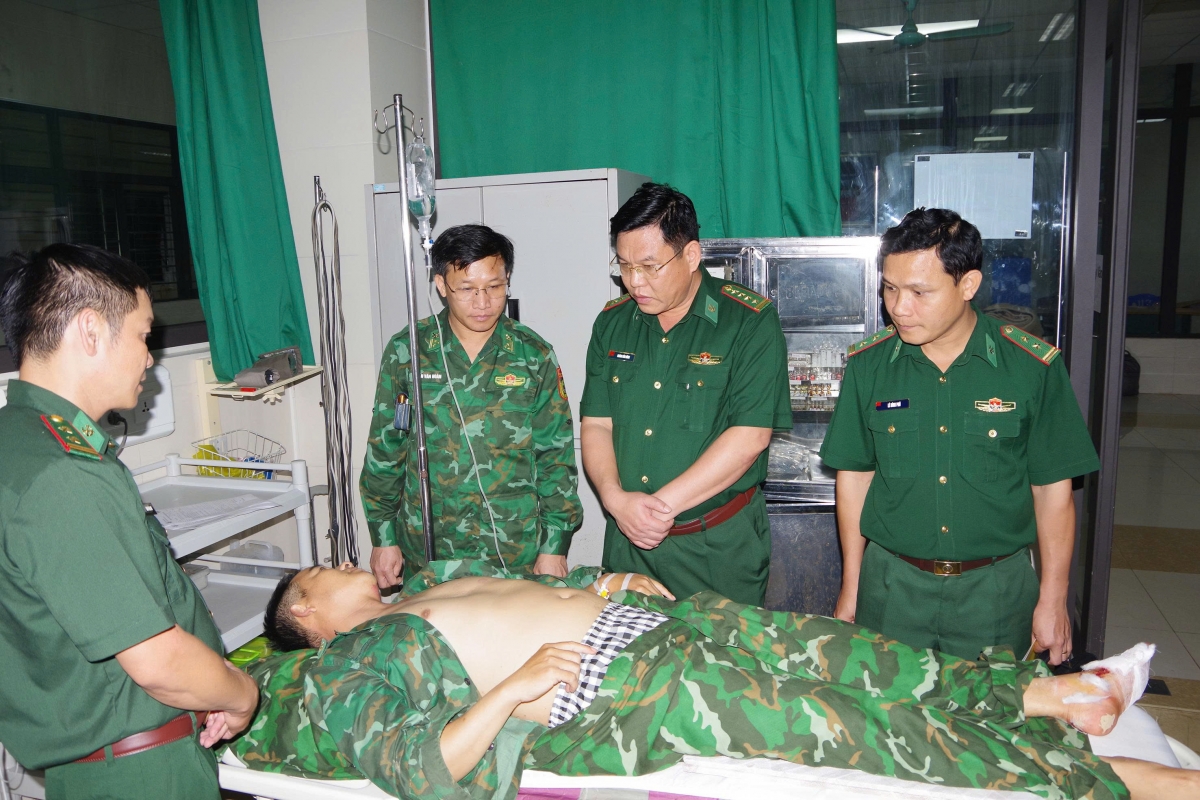 Đại tá Hoàng Văn Hùng, Chính ủy Ban Chỉ huy BĐBP tỉnh lên thăm, động viên Trung tá Lò Văn Hiền bị thương trong khi thực hiện nhiệm vụ (Ảnh: Trương Tùng)