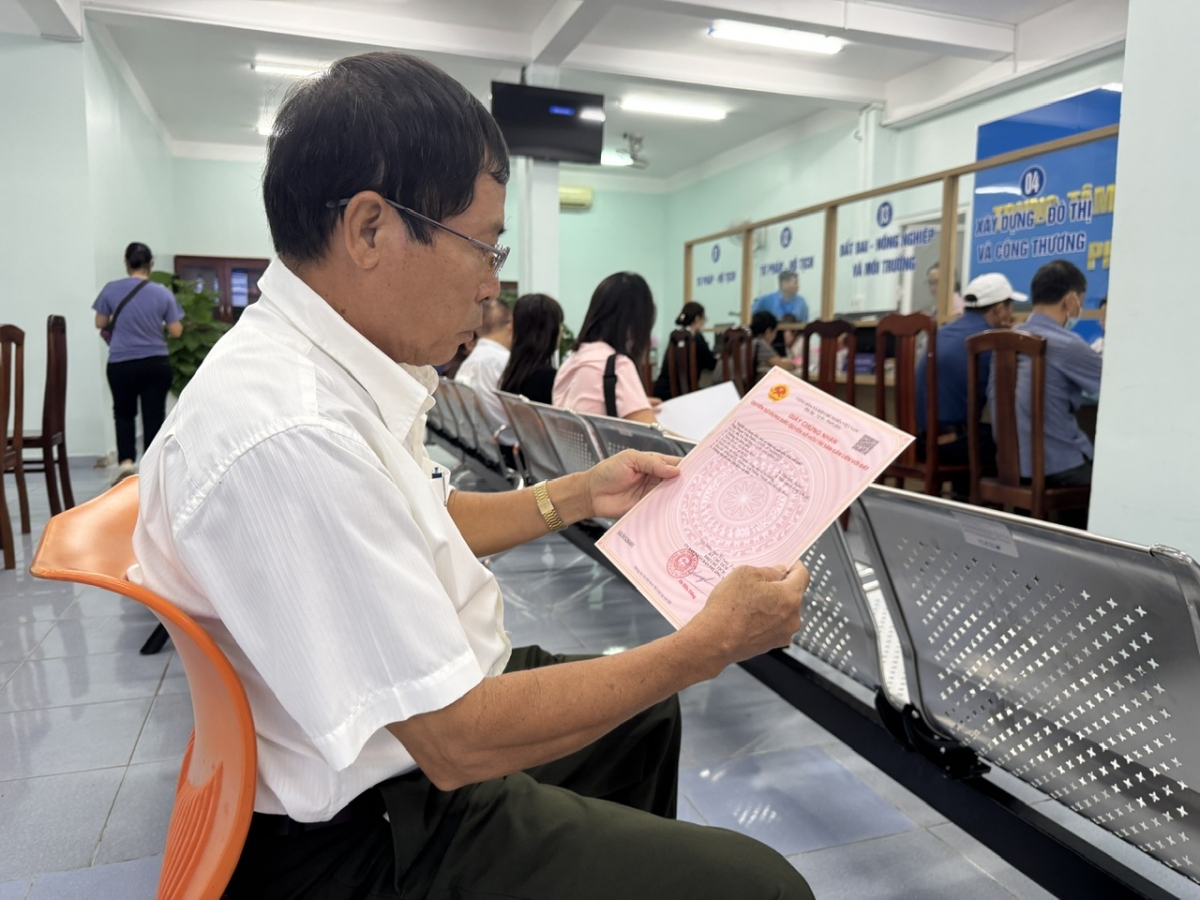 Ông Phạm Văn Viên vui mừng là người đầu tiên ở phường Tam Thắng được nhận sổ đỏ sau sáp nhập