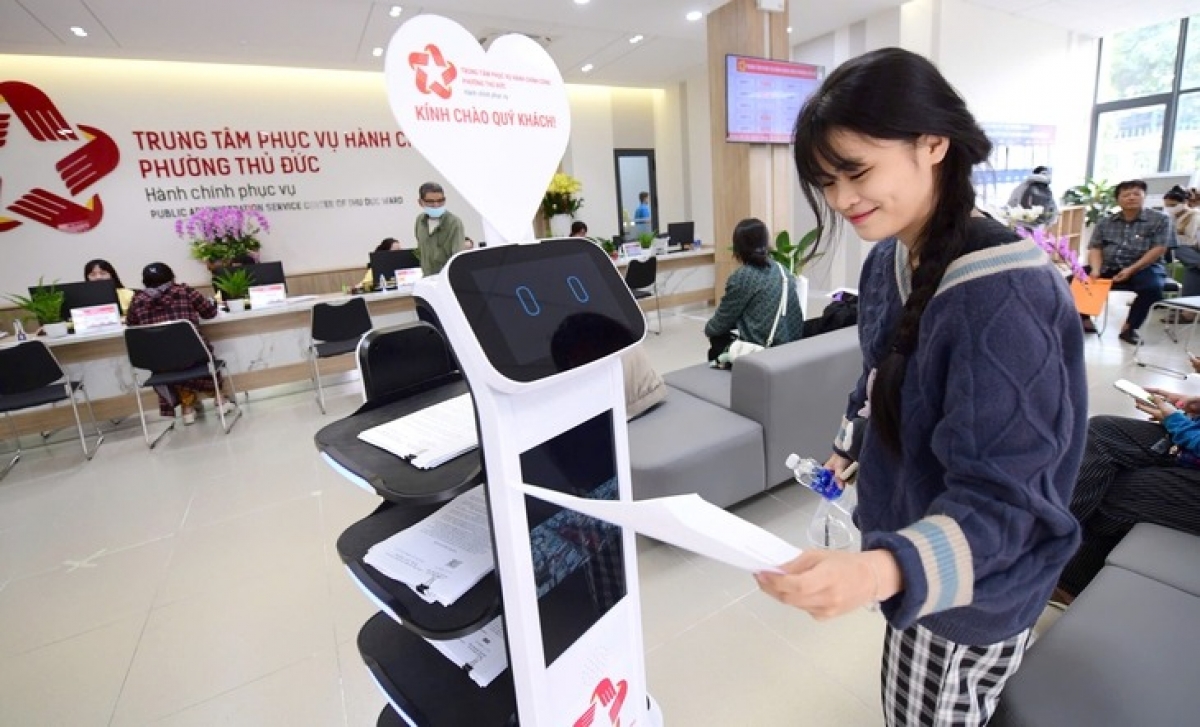 Chị Chu Uyên lấy hồ sơ trên robot hoạt động tại Trung tâm Phục vụ hành chính công phường Thủ Đức, TP.HCM để chứng thực hồ sơ xin việc làm.