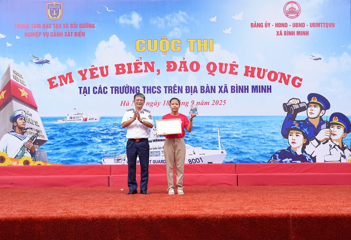 Đại tá Đặng Hồng Quân trao giải Nhất cho học sinh Bùi Bảo Ngọc.