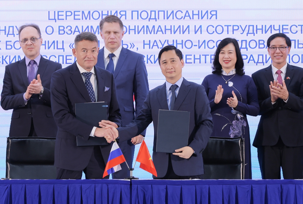 Ông Andrey Kaprin - Tổng giám đốc Trung tâm Y học Quốc gia về Xạ trị - Viện Hertsen Liên bang Nga trao đổi văn kiện hợp tác với ông Ngô Chí Dũng, Chủ tịch HĐQT Hệ thống BVĐK Tâm Anh và Viện Nghiên cứu Tâm Anh (TAMRI) tại lễ ký kết, với sự chứng kiến của Bộ trưởng Bộ Y tế Liên bang Nga Murashko Mikhail Albertovich và Bộ trưởng Bộ Y tế Đào Hồng Lan.