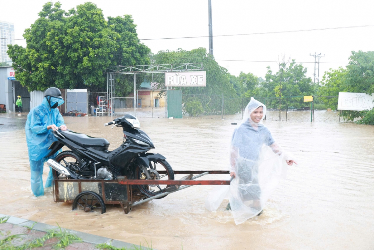 Người dân dùng xe kéo để chở phương tiện đi qua