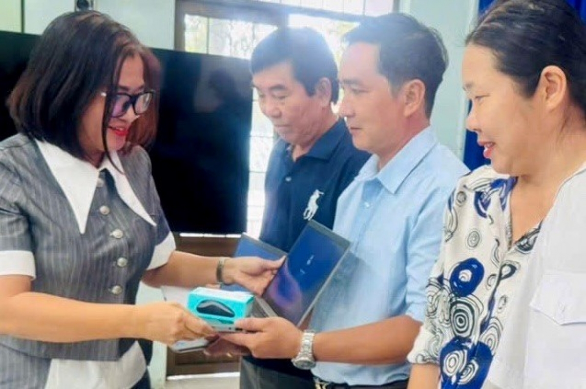 Bà Bùi Thị Thu Hương, Phó Chủ tịch UBND xã Long Sơn trao máy tính xách tay cho đại diện các thôn