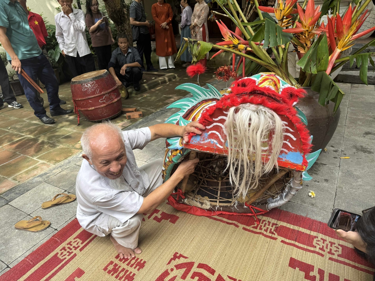 Ông Nguyễn Xuân Hiển, người trình diễn múa sư tử giới thiệu đến khách tham quan về kết cấu của đầu sư tử cổ