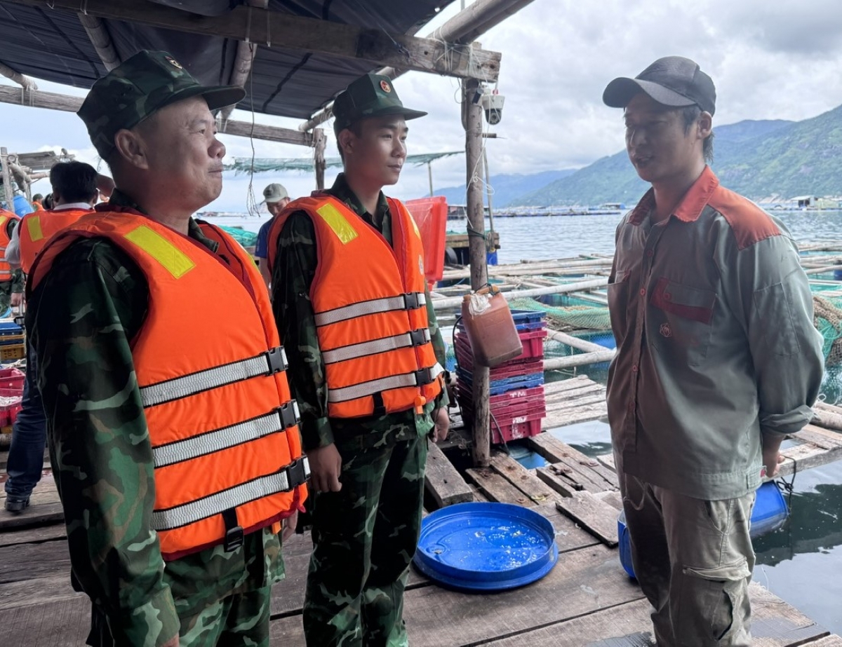 Cán bộ Đồn Biên phòng Cửa khẩu cảng Vũng Rô tuyên truyền người dân nuôi trồng thuỷ sản trên vịnh tuân thủ các biện pháp an toàn mùa mưa bão.