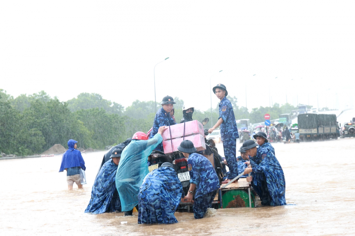 Cán bộ chiến sĩ Cảnh sát biển không quản ngại ngâm mình trong làn nước ngập sâu, trực tiếp vận chuyển từng người đi qua điểm ngập lụt