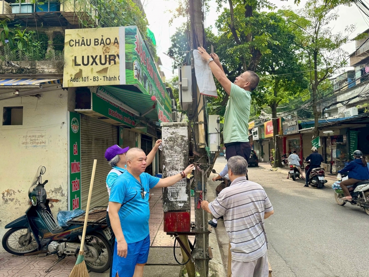 Người dân phường Giảng Võ bóc gỡ quảng cáo, rao vặt.