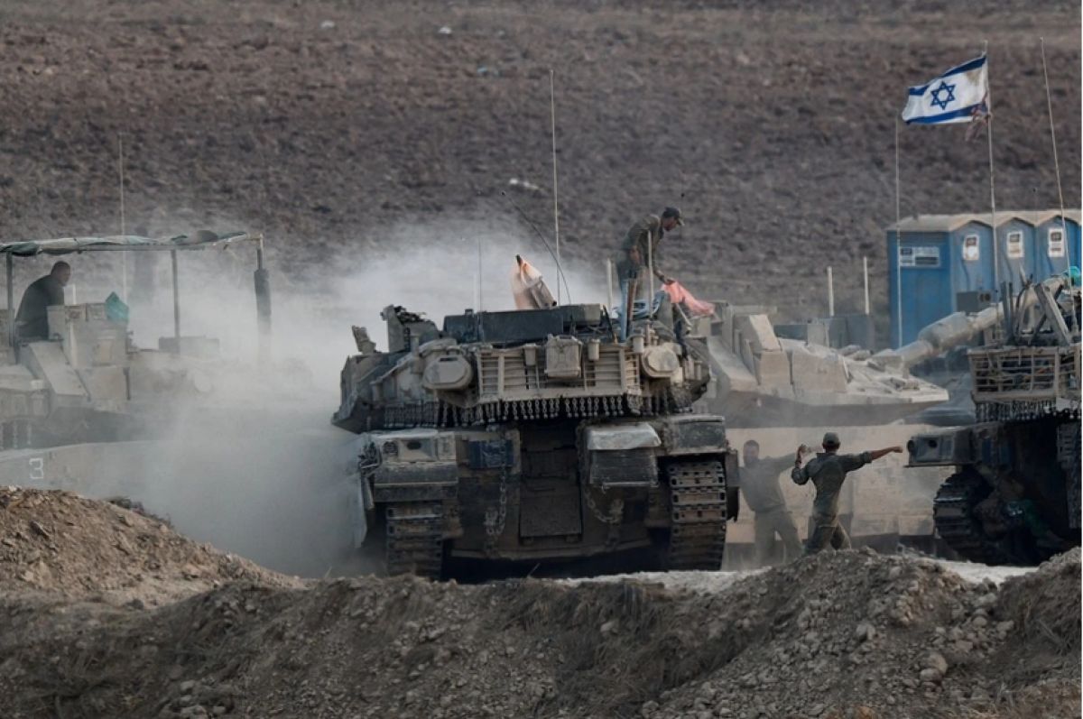 Binh lính Israel làm việc trên xe tăng, gần biên giới với Gaza. (Ảnh: Reuters)