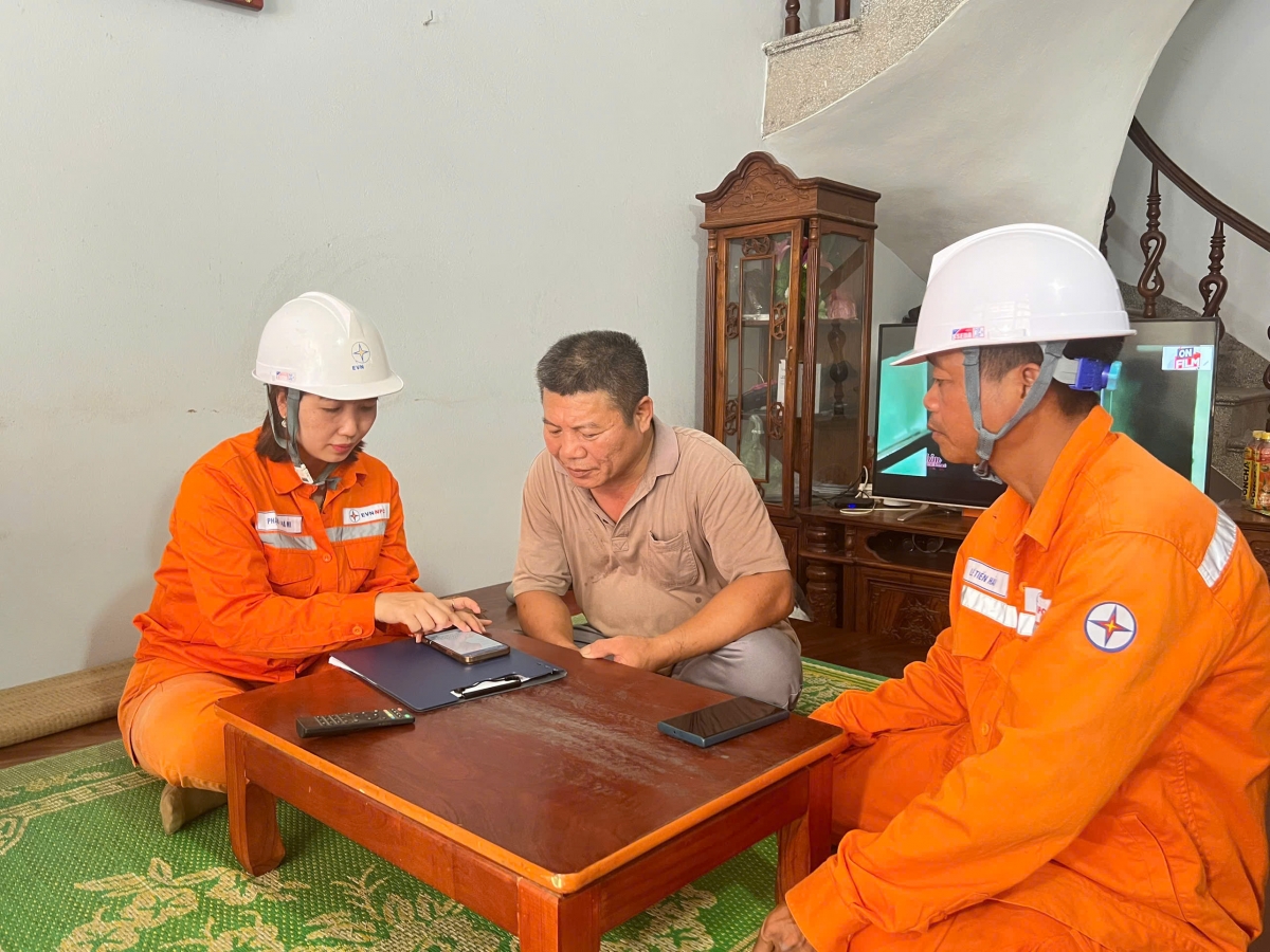Cán bộ điện lực Ninh Bình hướng dẫn khách hàng sử dụng app EVN.