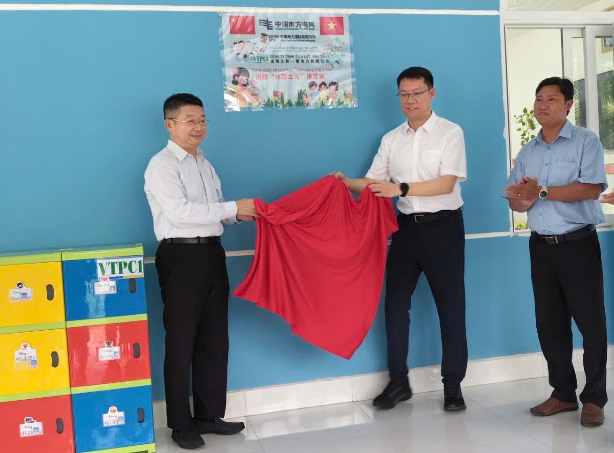 Ông Đường Lập (bìa trái), Tổng Lãnh sự quán Trung Quốc tại TP.HCM và lãnh đạo Điện lực Vĩnh Tân 1 kéo băng khánh thành phòng học mới
