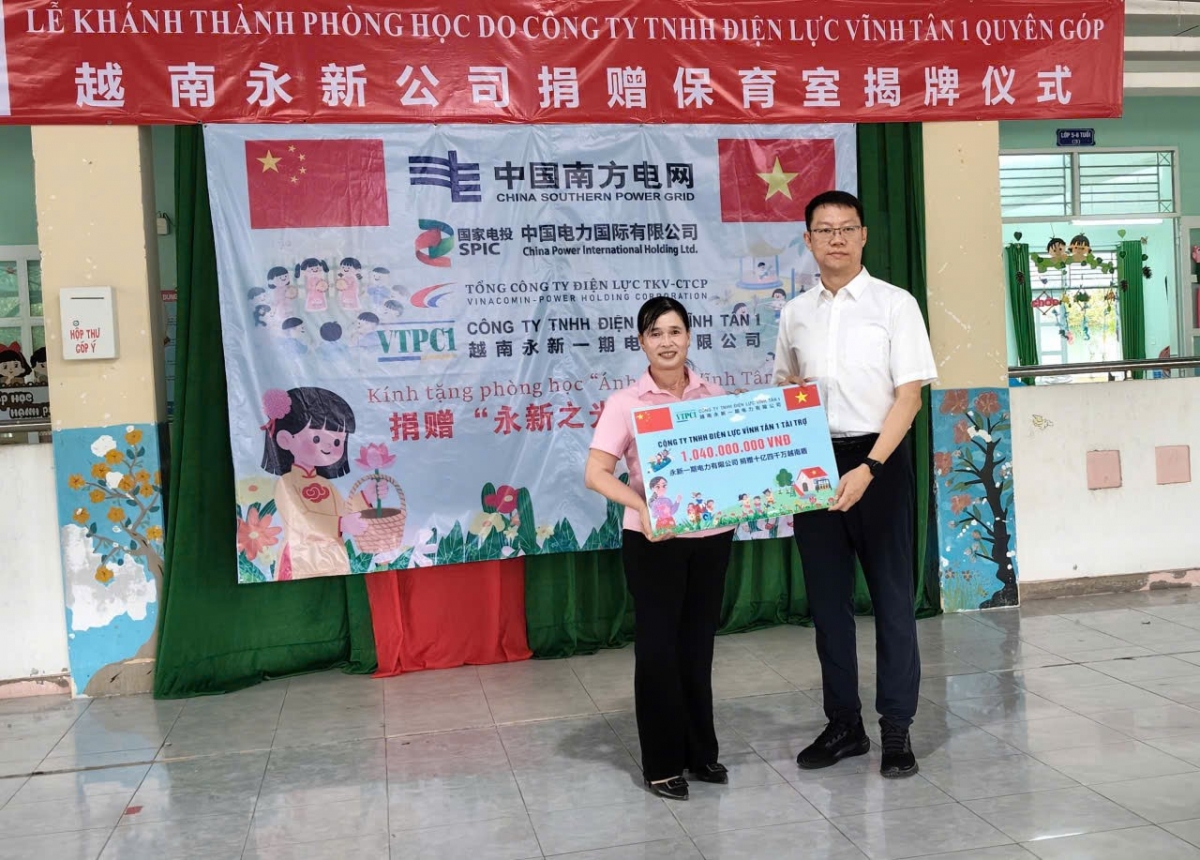 Đại diện nhà trường nhận bảng tượng trưng từ phía Điện lực Vĩnh Tân 1
