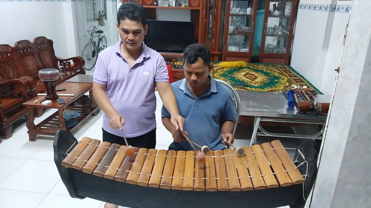 Anh Chơne Sô Pha Ra (Bên trái) đang tận tình hướng dẫn học viên chơi nhạc cụ