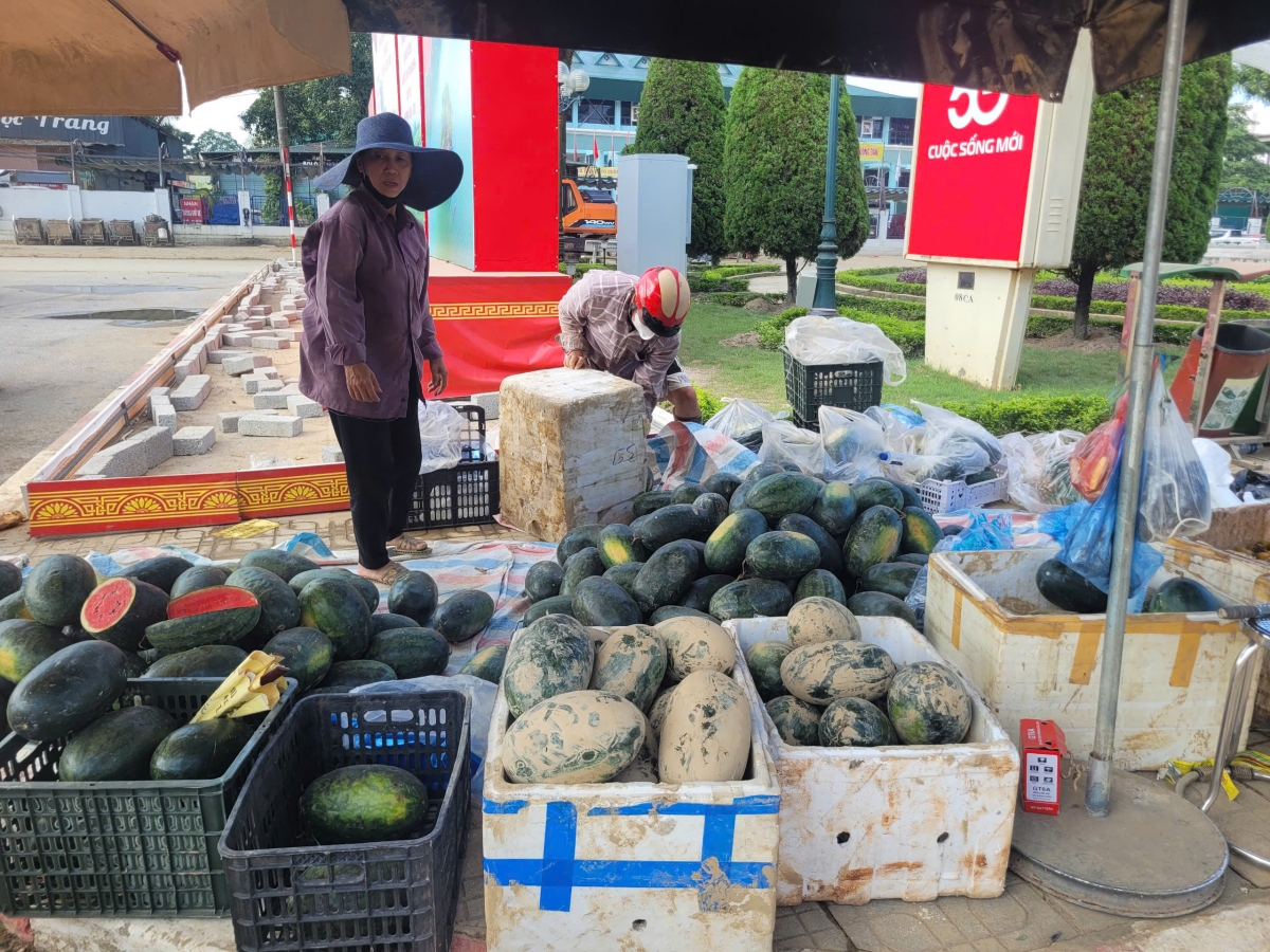 Bà Bùi Kim Thoa (phường Phan Đình Phùng) với những quả dưa còn lấm lem bùn đất, bày bán ngay quảng trường với hy vọng vớt lại chút vốn liếng.