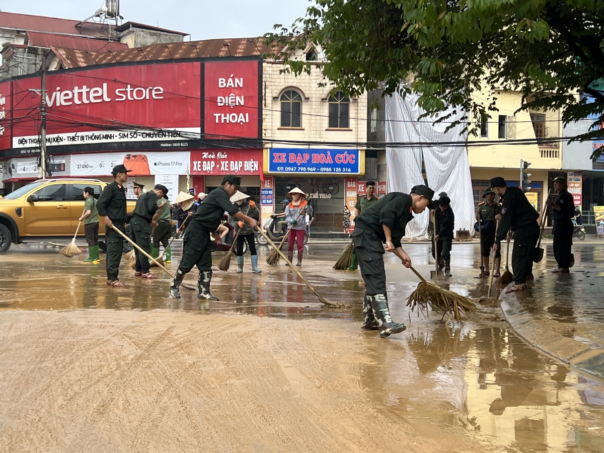 Chiến sỹ công an cùng người dân khẩn trương dọn bùn khi nước rút