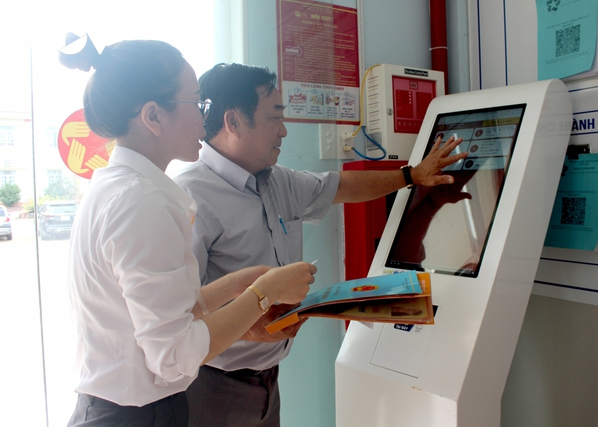 Người dân được hướng dẫn bốc số tự động tại ki-ốt