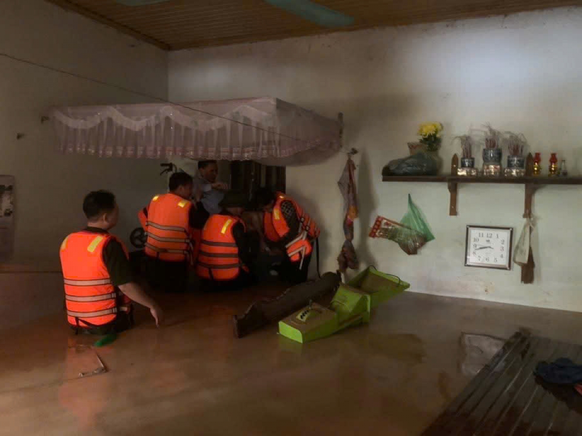 Lực lượng chức năng hỗ trợ nhân dân di dời đến nơi an toàn - Ảnh Mai Duy Đức.