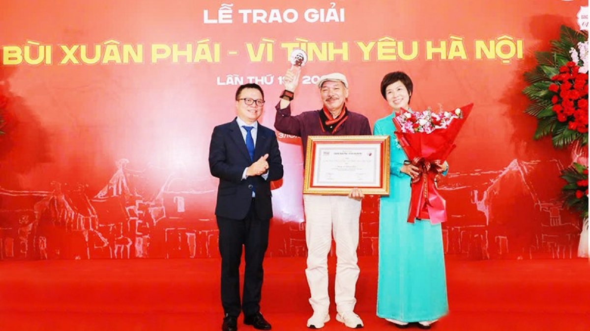 Nhà báo Lê Quốc Minh, Ủy viên Trung ương Đảng, Tổng Biên tập Báo Nhân Dân, Phó Trưởng ban Tuyên giáo và Dân vận Trung ương, Chủ tịch Hội Nhà báo Việt Nam và nhà báo Vũ Việt Trang, Tổng Giám đốc TTXVN trao Giải thưởng Lớn - Vì tình yêu Hà Nội cho nhạc sĩ Trần Tiến.
Ảnh: Phan Phương
