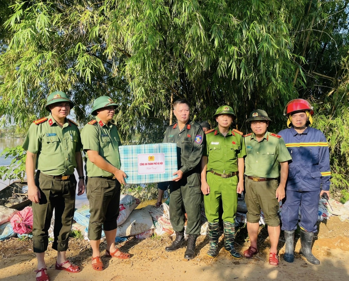 Thiếu tướng Nguyễn Hồng Nguyên và Đại tá Nguyễn Tiến Đạt, Phó giám đốc Công an TP Hà Nội cùng Đoàn công tác trao quà tặng lực lượng thực hiện nhiệm vụ tại hiện trường.