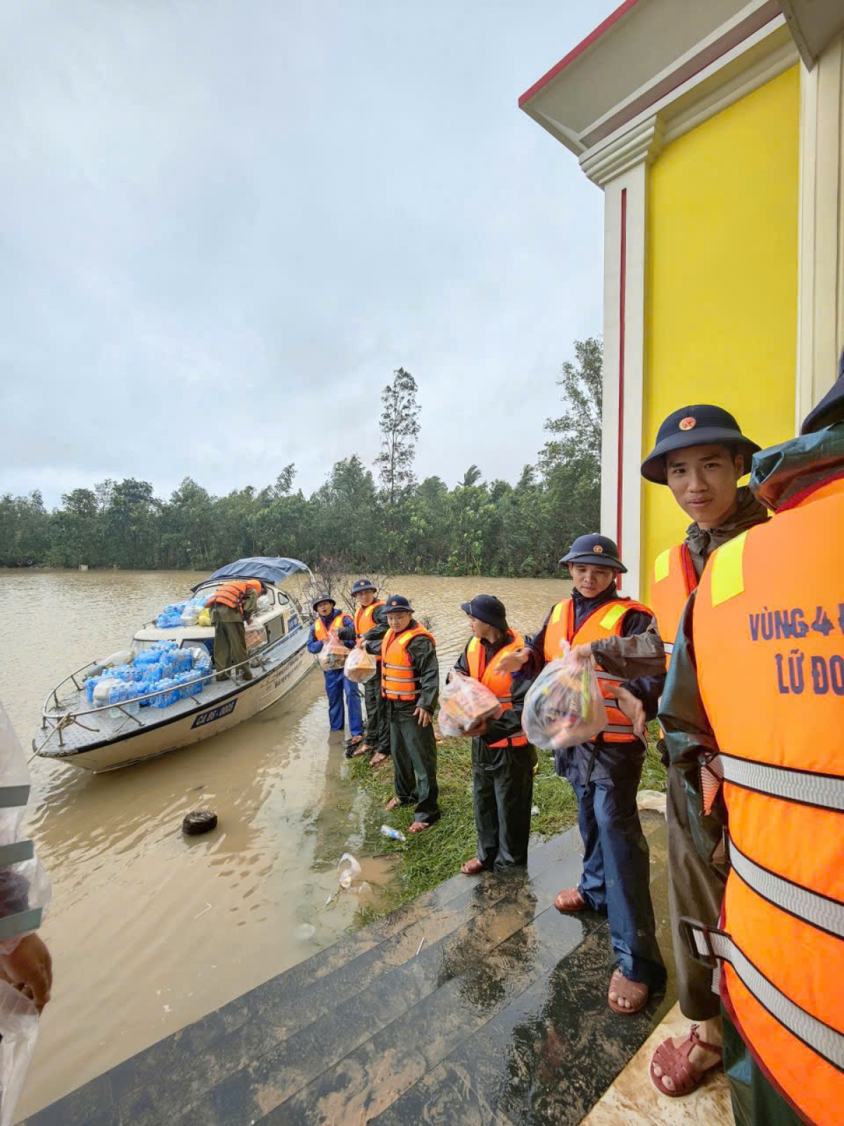 Cán bộ, chiến sỹ Lữ đoàn 682 phối hợp với chính quyền địa phương vận chuyển nhu yếu phẩm đến tay bà con nhân dân đang bị cô lập do nước lũ.