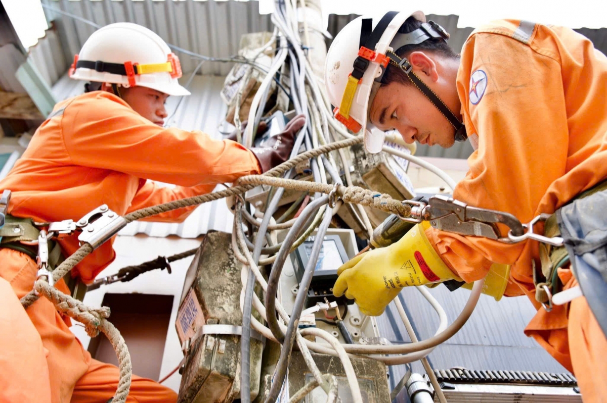 Các công nhân đang cố gắng nối lại đường dây bị lũ cuốn đứt tại một cụm dân cư ở xã Đông Hoà (huyện Đông Hoà, tỉnh Phú Yên cũ).