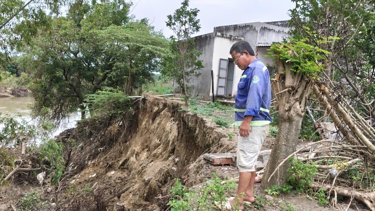 Trần Quang Đạt với vẻ lo lắng khi nhìn căn nhà của hàng xóm sắp "rớt" xuống sông
